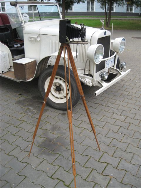 Старинный фотоаппарат (фотокамера) на деревянной треноге с магниевой вспышкой